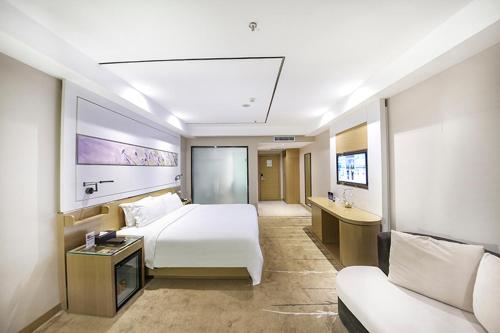 a hotel room with a bed and a couch at Lavande Hotel Beijing Asian Games Village in Beijing