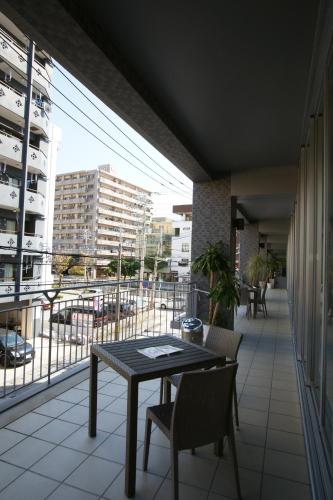 a table and chairs on a balcony with a view of a city at RJ Hotel Naha in Naha