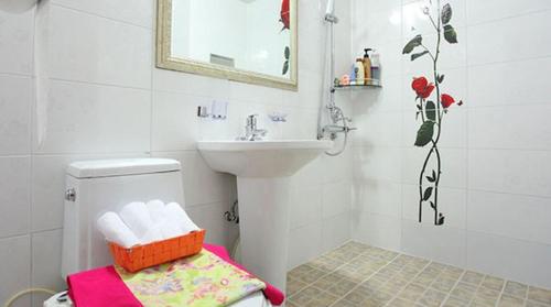 a white bathroom with a sink and a toilet at Tongyeong Bada Sarang Pension in Tongyeong