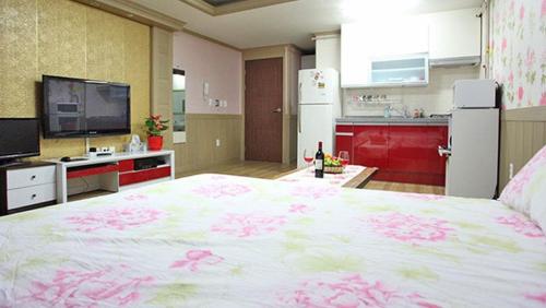 a bedroom with a large bed with pink flowers on it at Tongyeong Bada Sarang Pension in Tongyeong