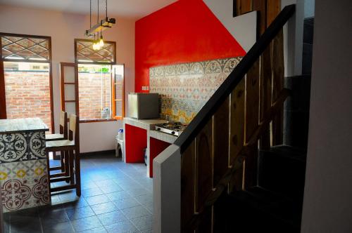 a kitchen with a staircase and a red wall at Villa Buddha Malioboro in Yogyakarta