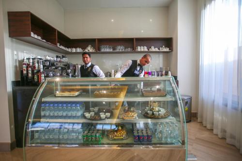 two men are standing behind a display case in a store at Tanuma Aram Hospitality - Hotel Apartments in Tanomah