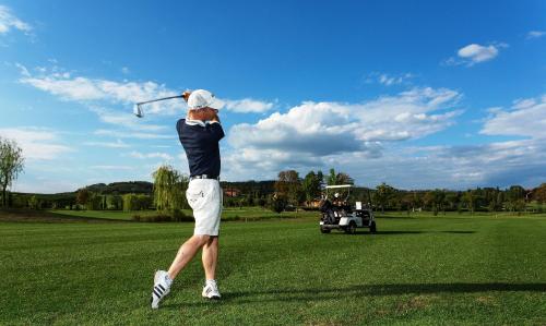 a man swinging a golf club on a golf course at La Tavernetta Al Castello in Capriva del Friuli