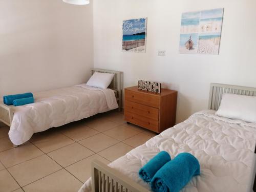 a bedroom with two beds and a wooden dresser at Lemon Tree Courtyard in Larnaca