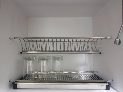 ein Regal in einem Kühlschrank mit vier Gläsern in der Unterkunft KVA Syariah 4BR in Bekasi