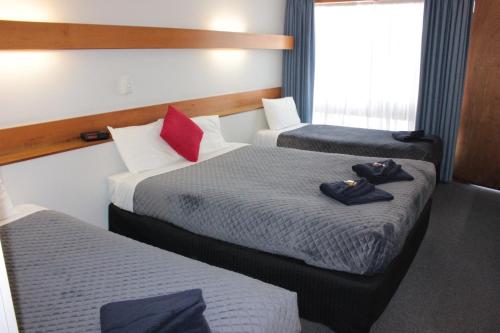 a hotel room with two beds with towels on them at Glynlea Motel in Horsham