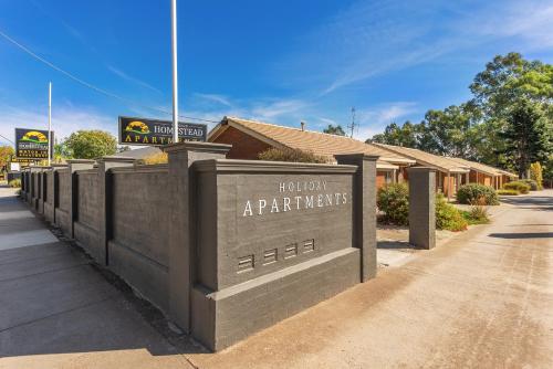 a sign that says troll butappartments on a fence at Homestead Motor Inn & Apartments in Bendigo