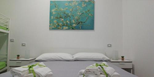 a bedroom with a bed and a painting on the wall at B&B Sole Mare Vento in Maruggio