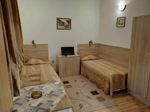 ヴァルナ・シティにあるPrivate rooms Siestaのベッド2台とテーブルが備わる客室です。
