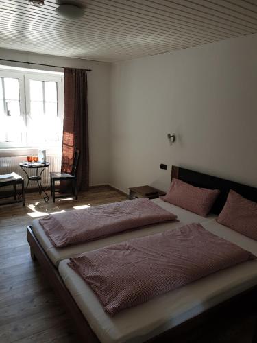1 dormitorio con 2 camas, mesa y ventana en Gastehaus in der Alte Kellerei en Kobern-Gondorf