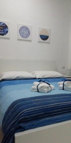 a bed with blue and white sheets and plates on it at B&B Sole Mare Vento in Maruggio