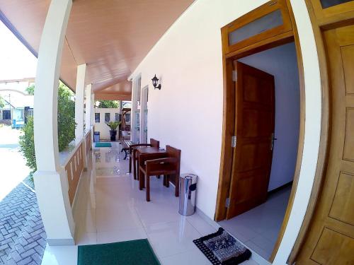 um corredor de uma casa com uma porta e cadeiras em Amaryllis Guesthouse Syariah em Pacitan