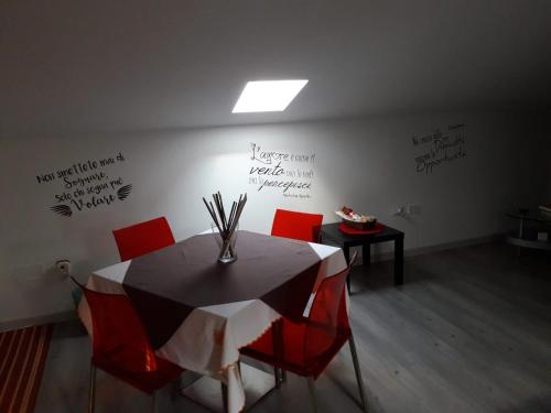 a dining room with a table and chairs with writing on the wall at Tigli Carraro in San Cataldo