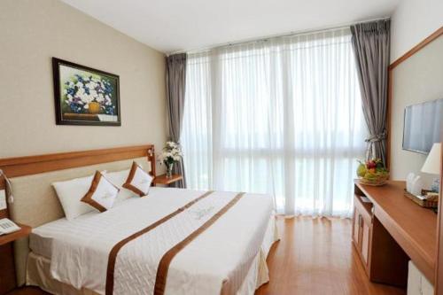 a hotel room with a bed and a large window at Dendro beachfront Hotel in Nha Trang
