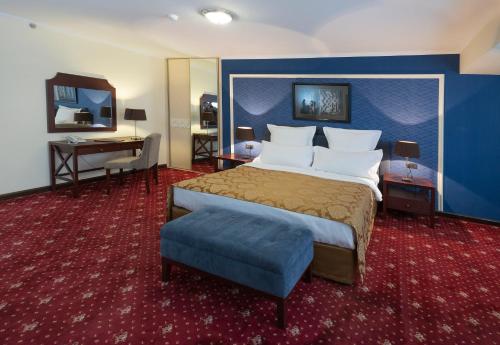een hotelkamer met een groot bed en een bureau bij Ani Plaza Hotel in Jerevan