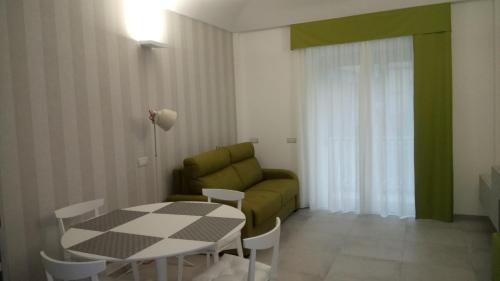 ein Wohnzimmer mit einem Tisch und einem grünen Sofa in der Unterkunft ChiàRò-La casa al mare in Minori
