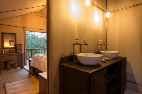 a bathroom with two sinks on top of a counter at Vuyani Safari Lodge in Hoedspruit