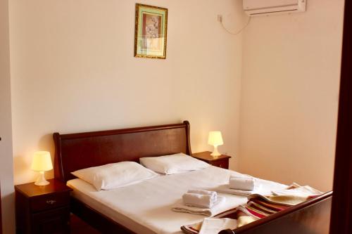 a bedroom with a bed with two lamps and towels at Nir Apartments Budva in Budva
