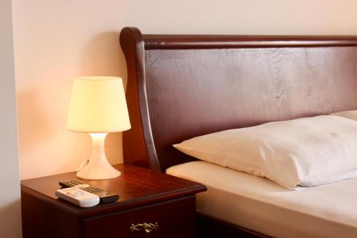 a lamp on a nightstand next to a bed at Nir Apartments Budva in Budva