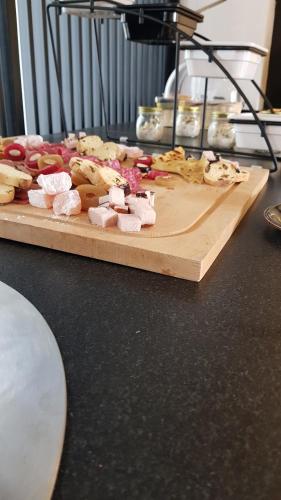 a wooden cutting board with different types of food on it at Abacus Suites in Ayia Napa