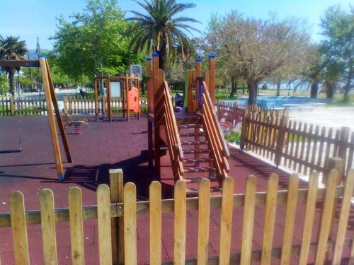 a playground in a park with a wooden fence at Central Fountain in Asprovalta