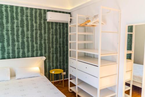 a bedroom with a bed and a white book shelf at Casa do Pateo II in Évora