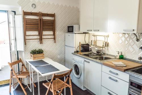 a kitchen with a sink and a table with chairs at Casa do Pateo II in Évora