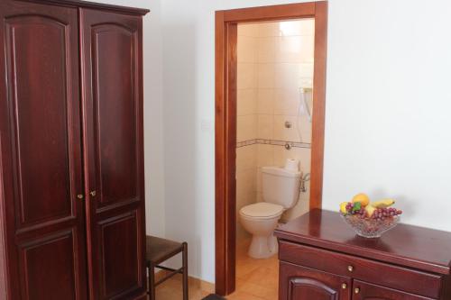 a bathroom with a toilet and a bowl of fruit on a dresser at Nir Apartments Budva in Budva