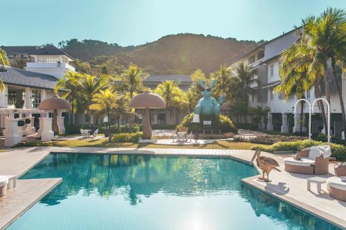 a swimming pool with a bird standing in front of a building at Dash Resort Langkawi in Pantai Cenang