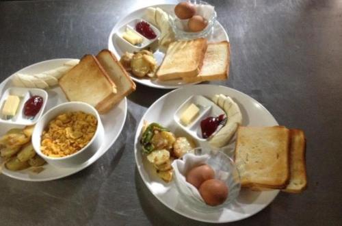 uma mesa com três pratos de comida com ovos e pão em HOTEL ICE VIEW POKHARA em Pokhara