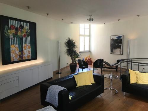a living room with a black couch and chairs at The Art Residence Maastricht in Maastricht