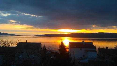 a sunset over a large body of water at Apartman Petra in Senj