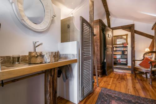 une salle de bain avec un lavabo et un miroir dans l'établissement Haras Picard du Sant, à Lasserre