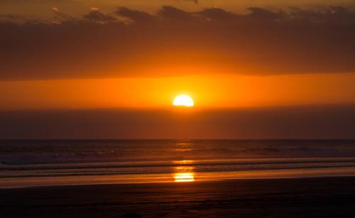 a sunset on the beach with the sun setting at Paradiselodge Jungleguesthouse in Platanillo
