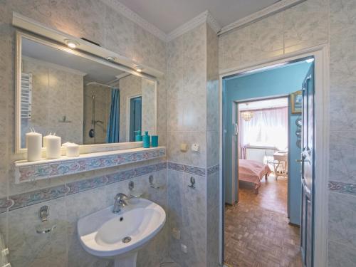 ein Bad mit einem Waschbecken und einem Spiegel in der Unterkunft Apartament Starogdański Nad Motławą in Danzig