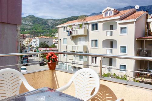 a balcony with a table and chairs and a view of a city at Nir Apartments Budva in Budva