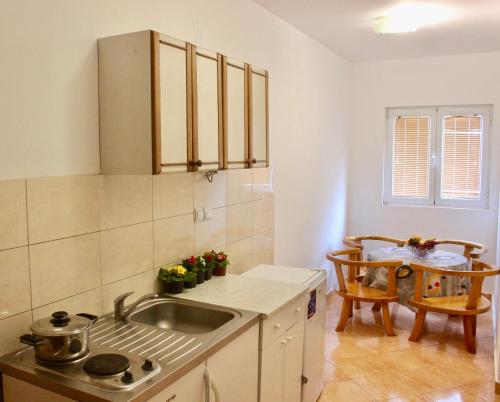 a kitchen with a sink and a table at Nir Apartments Budva in Budva