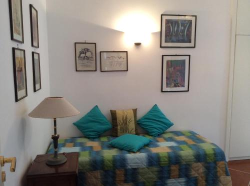 a room with a bed with blue pillows and a lamp at Villa Le Palme in Rosa Marina