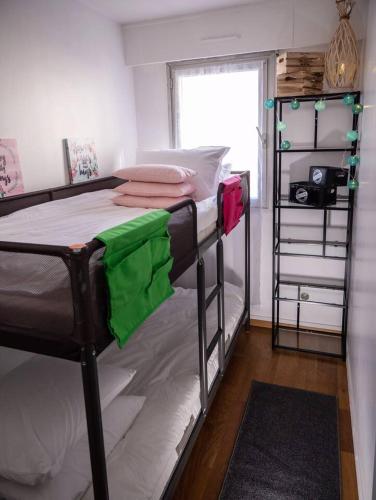 une chambre avec deux lits superposés et une fenêtre dans l'établissement Les pieds dans l'eau accès direct à la plage !, à Granville