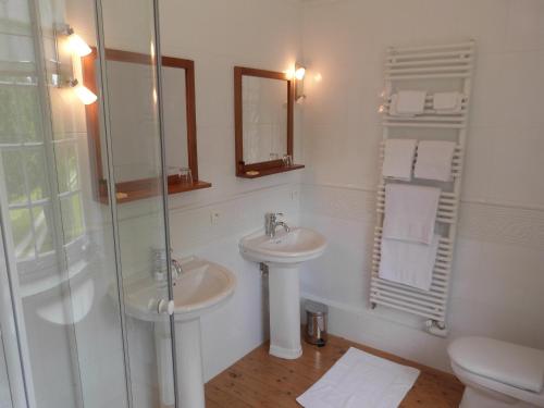 a white bathroom with a sink and a shower at Bruce Castle in Brix