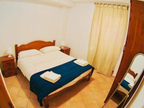 マリーナ・ディ・ラグーザにあるLe Amicheのベッドルーム1室(ベッド1台、タオル2枚付)