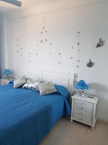 a bedroom with a blue bed and a white wall at Holiday wanda in Fuengirola