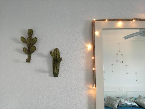 a mirror and a cactus on a wall with lights at Holiday wanda in Fuengirola