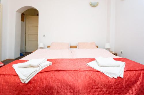 a large red bed with white towels on it at Apartments Ozren in Soko Banja