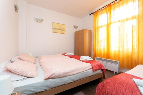 a bedroom with two beds and a window at Apartments Ozren in Soko Banja