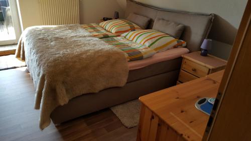 a bed with a blanket on it in a bedroom at Ferienwohnung Stadie in Dörphof