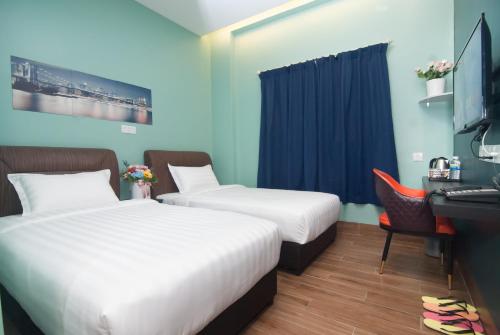 ジョホールバルにあるGOOD 9 HOTEL - Bukit Dahliaのベッドが2つと机とコンピューターがある部屋