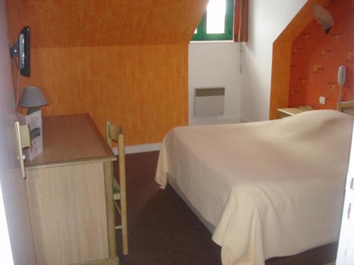 Schlafzimmer mit einem Bett, einem Tisch und einem Fenster in der Unterkunft Les Voyageurs in Sizun
