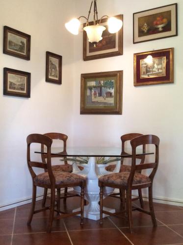 a dining room with a glass table and four chairs at Villa Le Palme in Rosa Marina