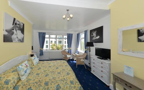a bedroom with a bed and a tv and a desk at Blue Palms in Bournemouth